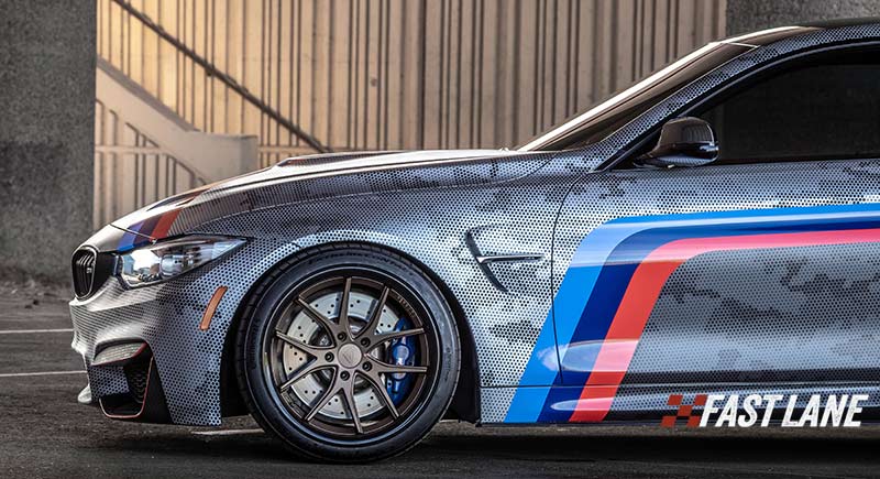 Wrapped BMW m4 with vinyl BMW decal stripes in red, royal blue, and navy blue.