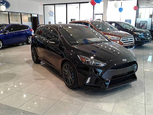 Ford Focus STI with window tinting on dealer showroom floor.