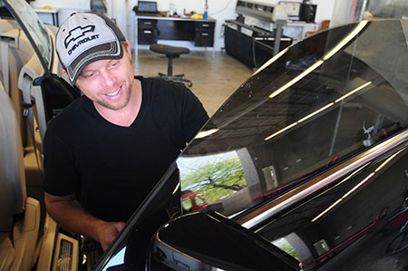 Jonathan doing a premium window tint on the driver's window.