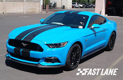 White Ford Mustang with dual blue vinyl stripes.