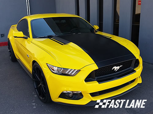 White Ford Mustang with dual blue vinyl stripes.